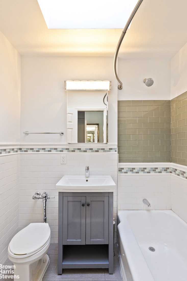 435 East 85th Street, Unit 4C Manhattan, NY 10028 - Photo 6 of 9 a bathroom with a sink a toilet and mirror