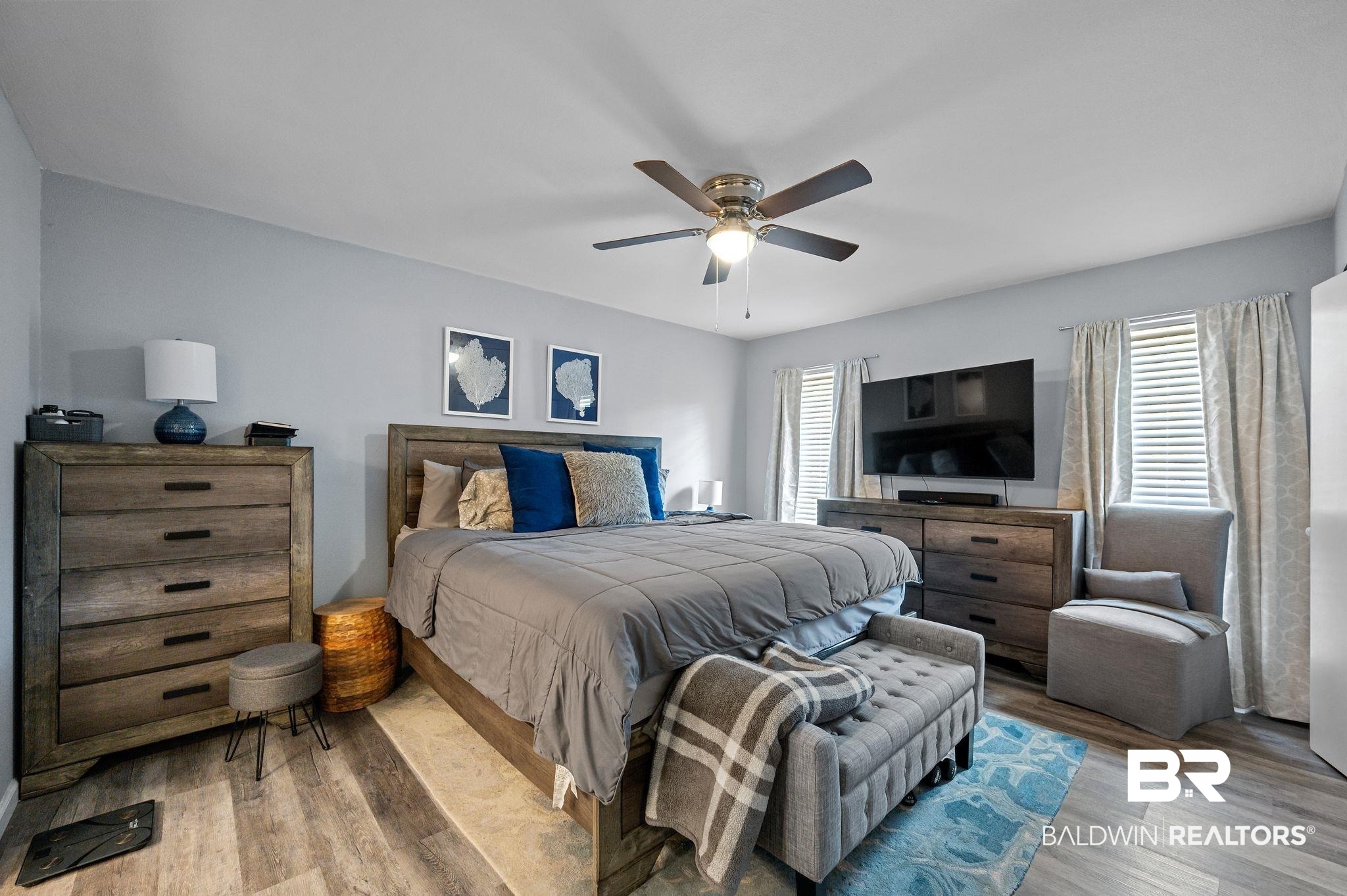 4724 Wicker Way Mobile, AL 36609 - Photo 20 of 36 Spacious interior featuring a ceiling fan with integrated lighting, two windows with blinds and curtains, and wood-finish flooring