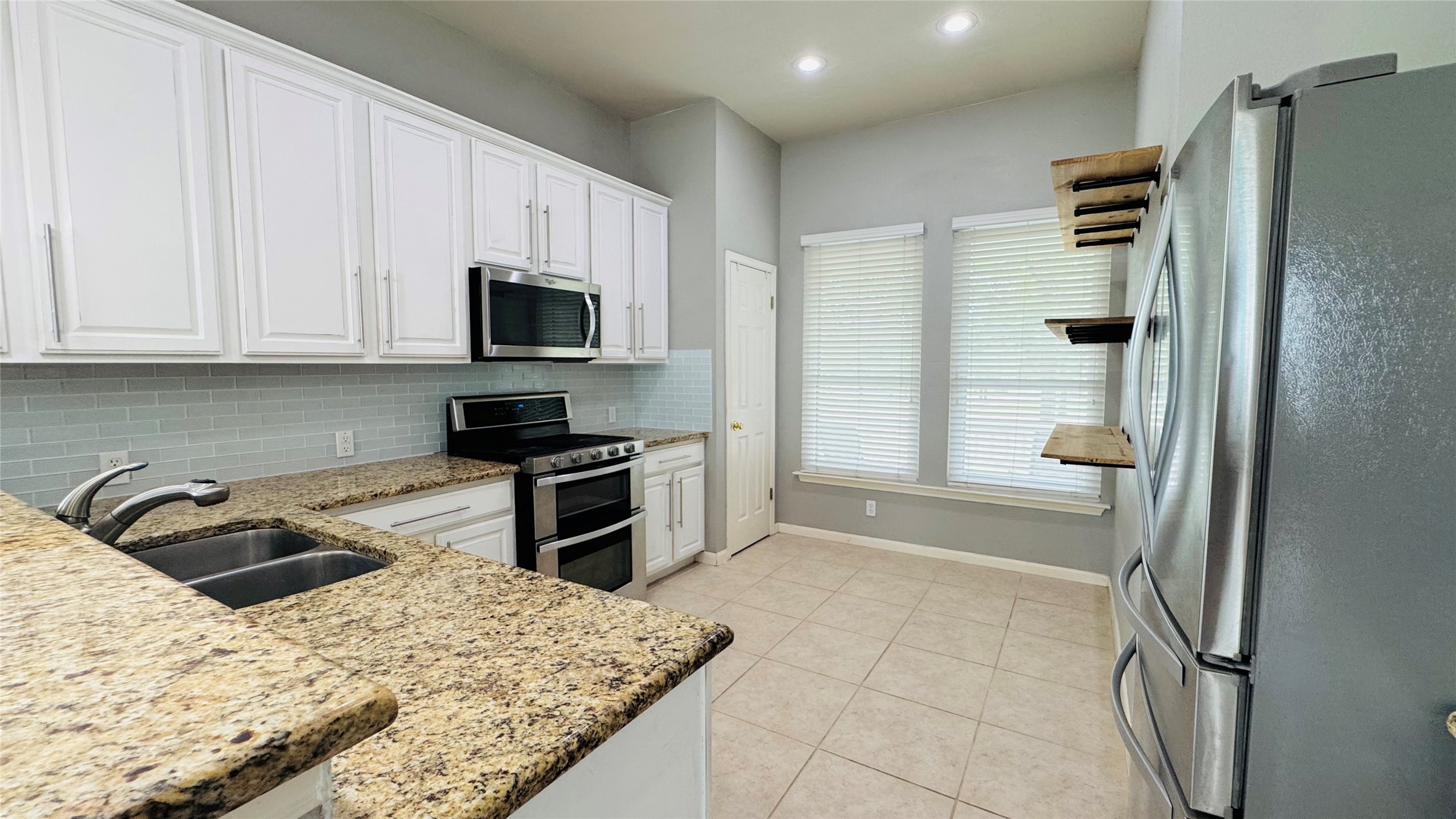 401 Witte Road Kyle, TX 78640 - Photo 3 of 9 Culinary delights await in this modern kitchen with granite countertops and abundant white cabinetry.