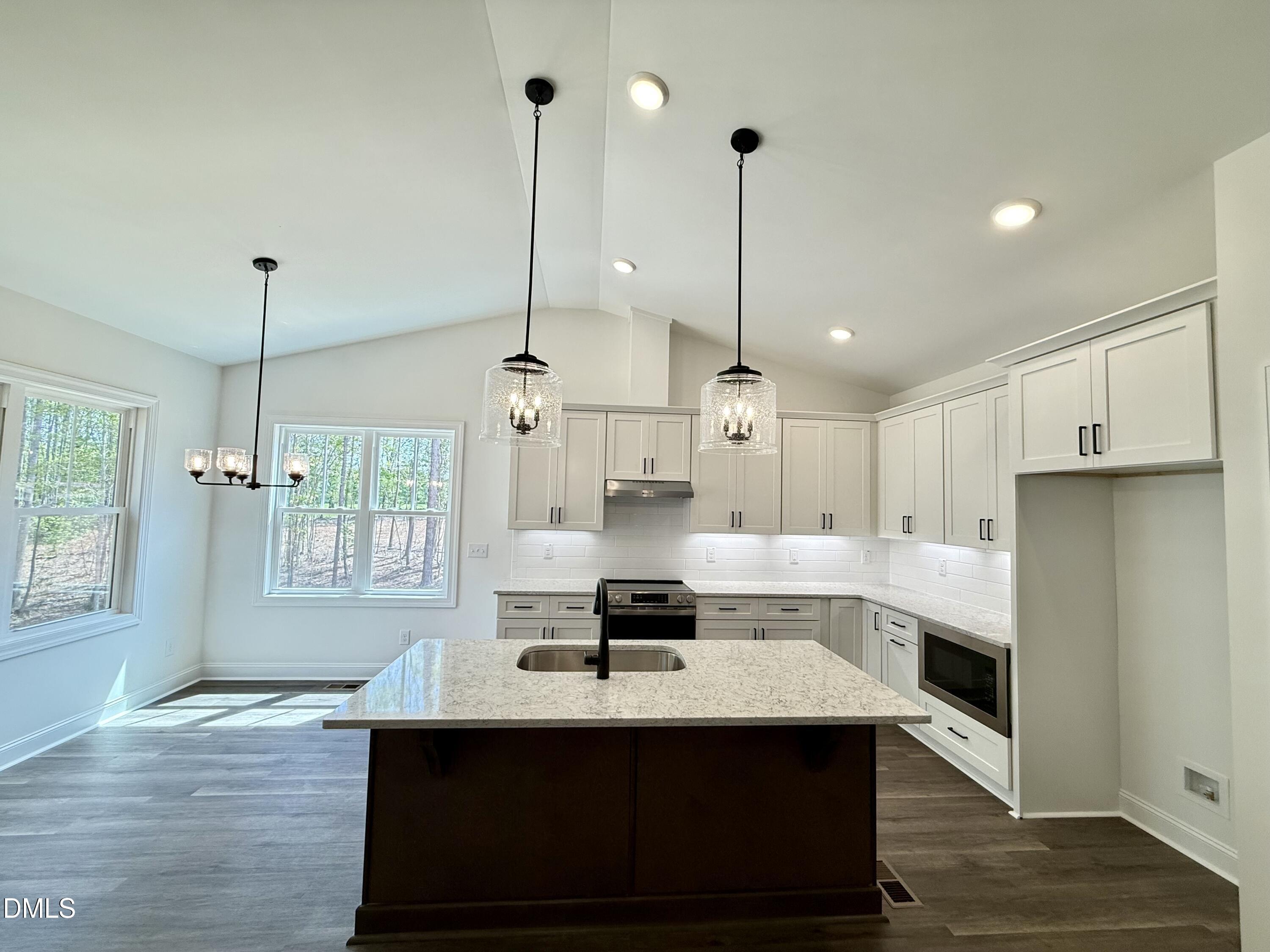 10300 Stallings Road Spring Hope, NC 27882 - Photo 16 of 36 a view of a kitchen with kitchen island a sink stainless steel appliances and cabinets