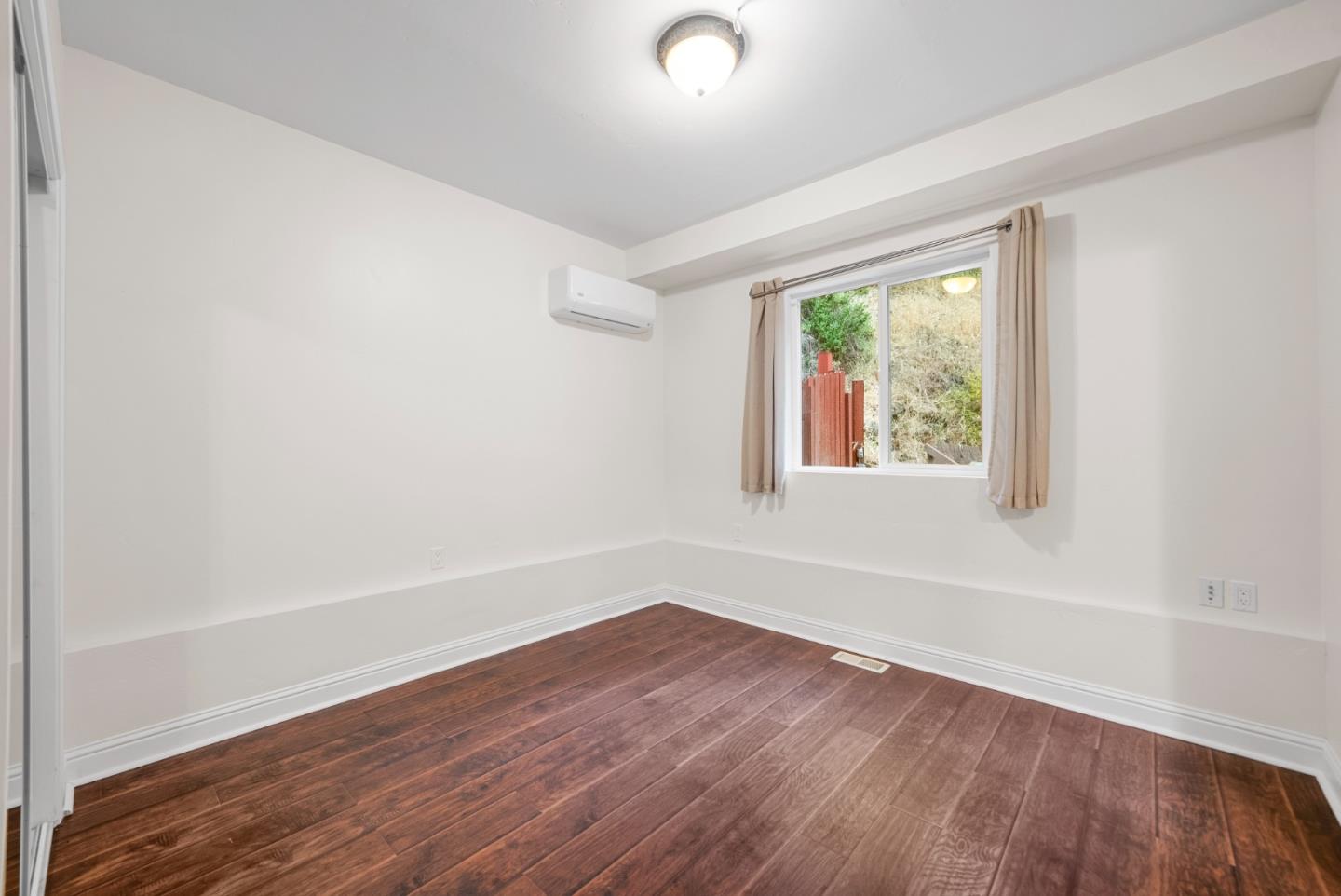 975 Logan Creek Road Boulder Creek, CA 95006 - Photo 28 of 41 an empty room with wooden floor and windows