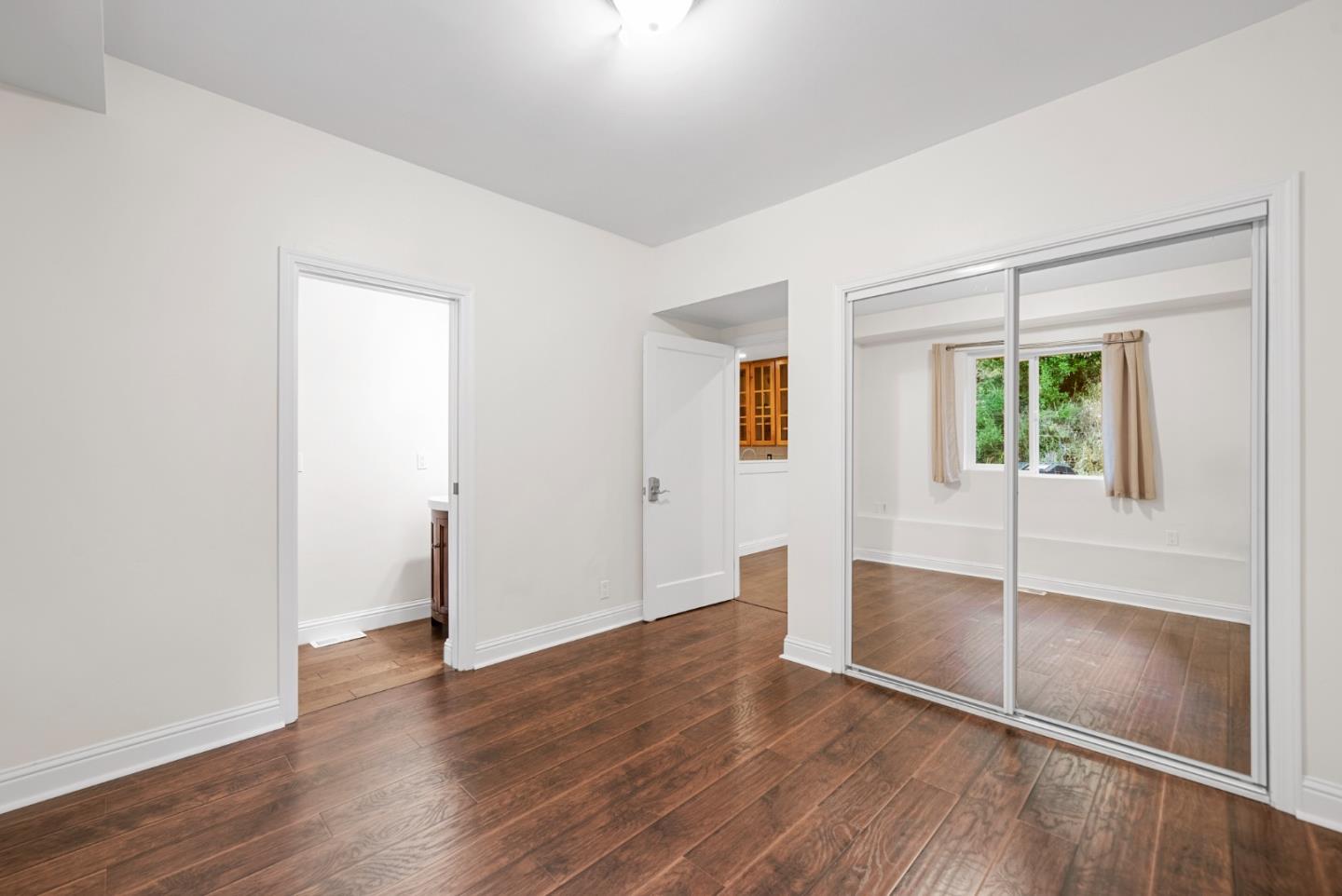 975 Logan Creek Road Boulder Creek, CA 95006 - Photo 30 of 41 an empty room with wooden floor and windows