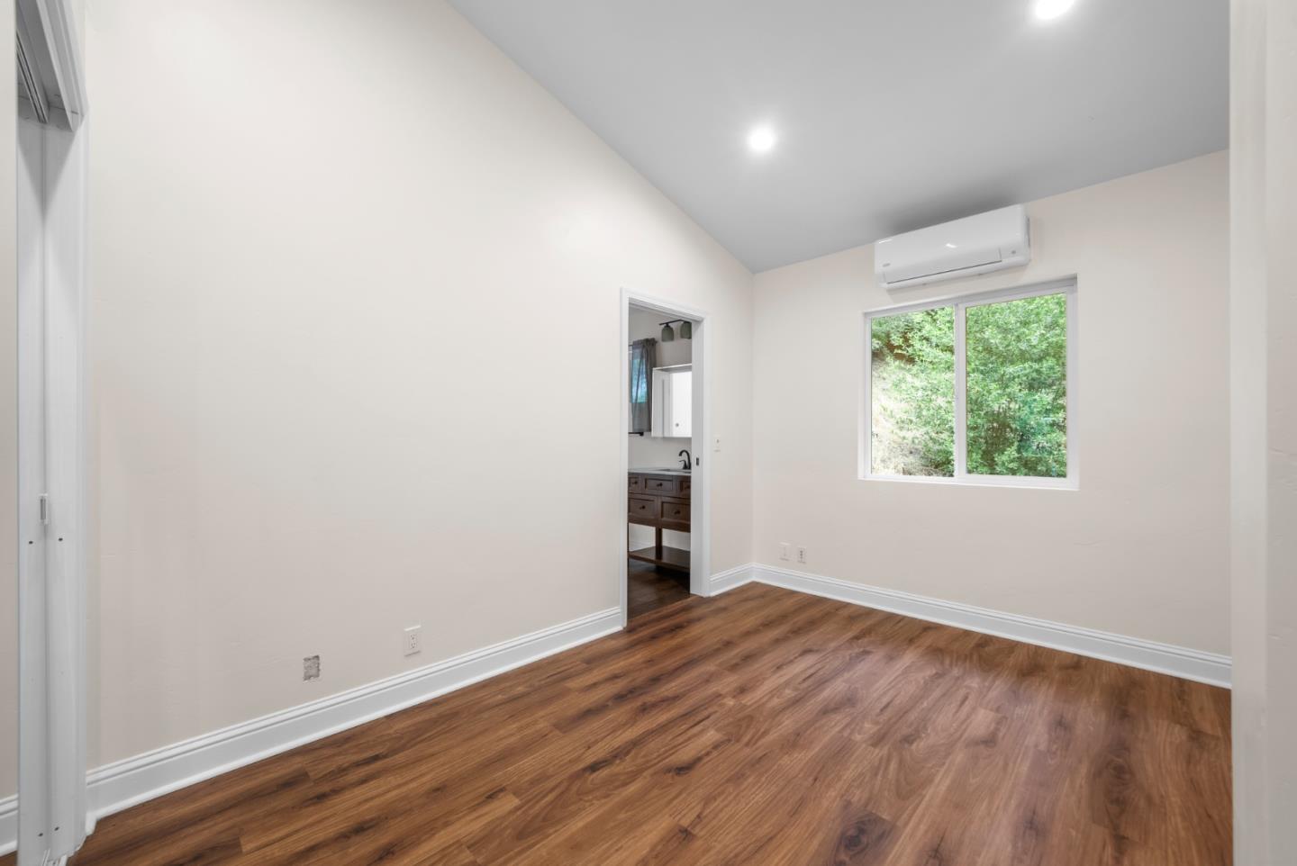 975 Logan Creek Road Boulder Creek, CA 95006 - Photo 38 of 41 an empty room with wooden floor and windows