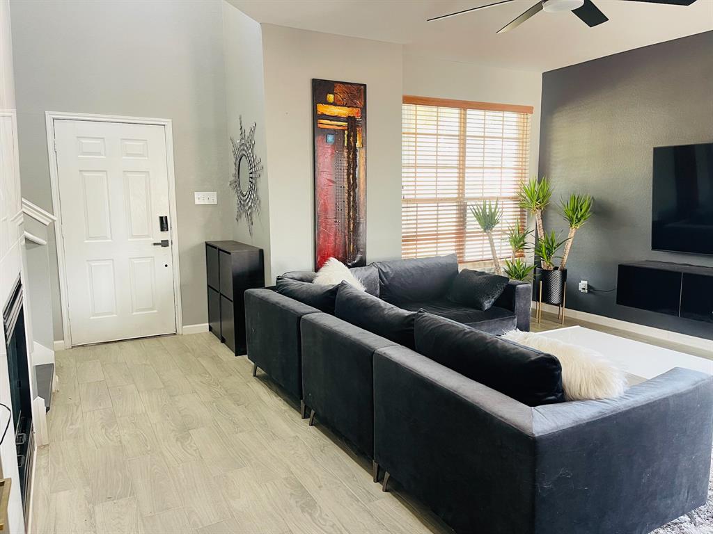 516 Angela Lane Euless, TX 76039 - Photo 5 of 39 Living area featuring light wood finished floors, a fireplace, and a ceiling fan