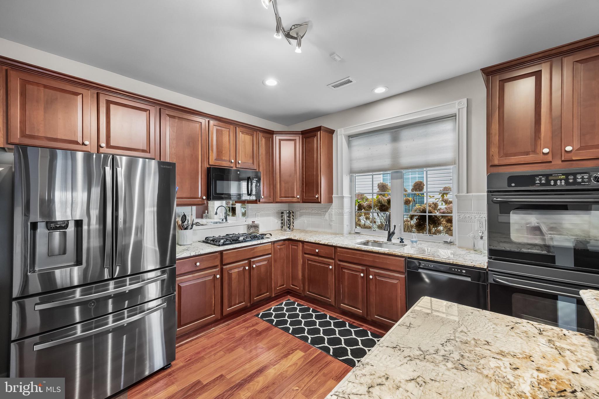 77 Pennington Court Delanco, NJ 08075 - Photo 13 of 46 a kitchen with stainless steel appliances granite countertop a refrigerator and wooden cabinets