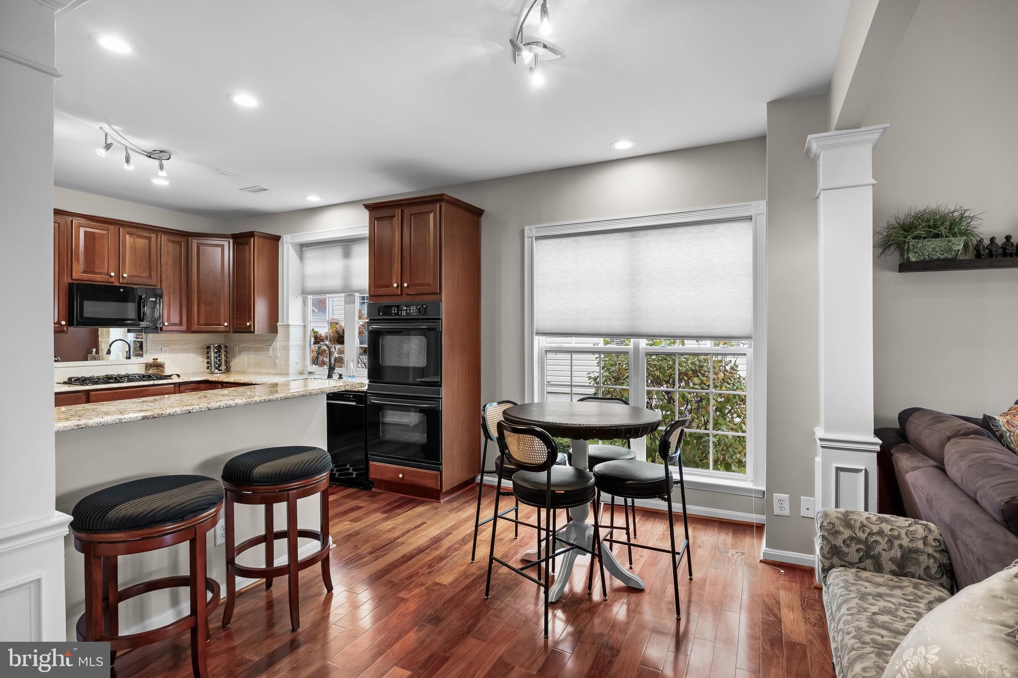 77 Pennington Court Delanco, NJ 08075 - Photo 15 of 46 a kitchen with stainless steel appliances granite countertop a stove top oven a sink dishwasher a dining table and chairs with wooden floor