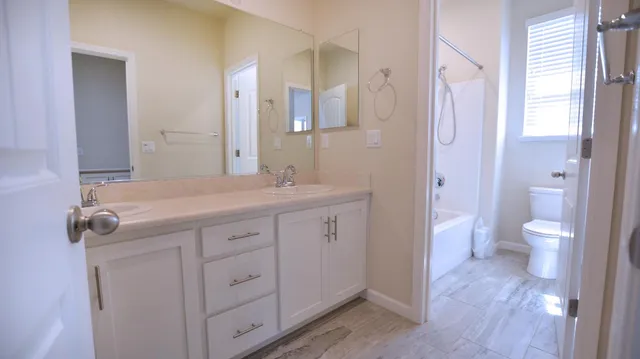 a bathroom with a sink a toilet and shower