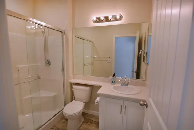 a bathroom with a granite countertop sink toilet and shower