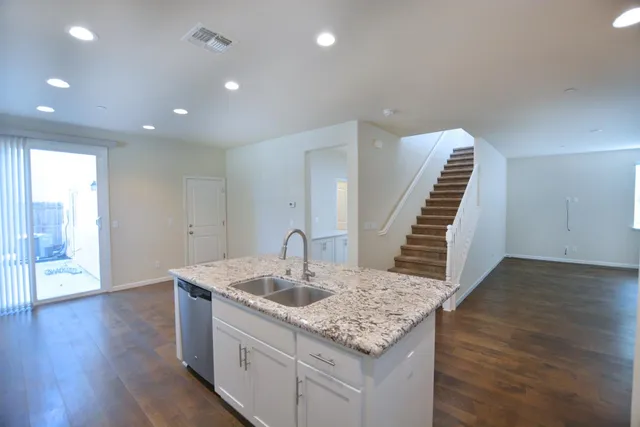 a kitchen with a sink and wooden floor
