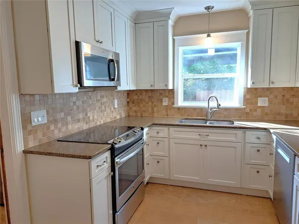 a kitchen with stainless steel appliances granite countertop a sink stove and microwave