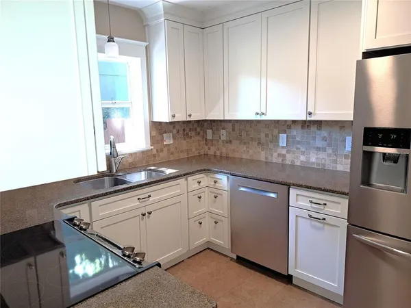 a kitchen with granite countertop white cabinets and white appliances