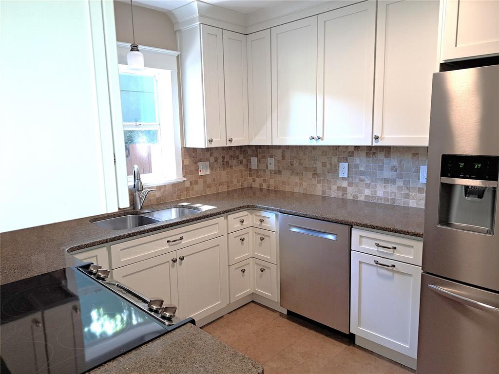 1835 Edwin Boulevard Winter Park, FL 32789 - Photo 14 of 49 a kitchen with granite countertop white cabinets and white appliances