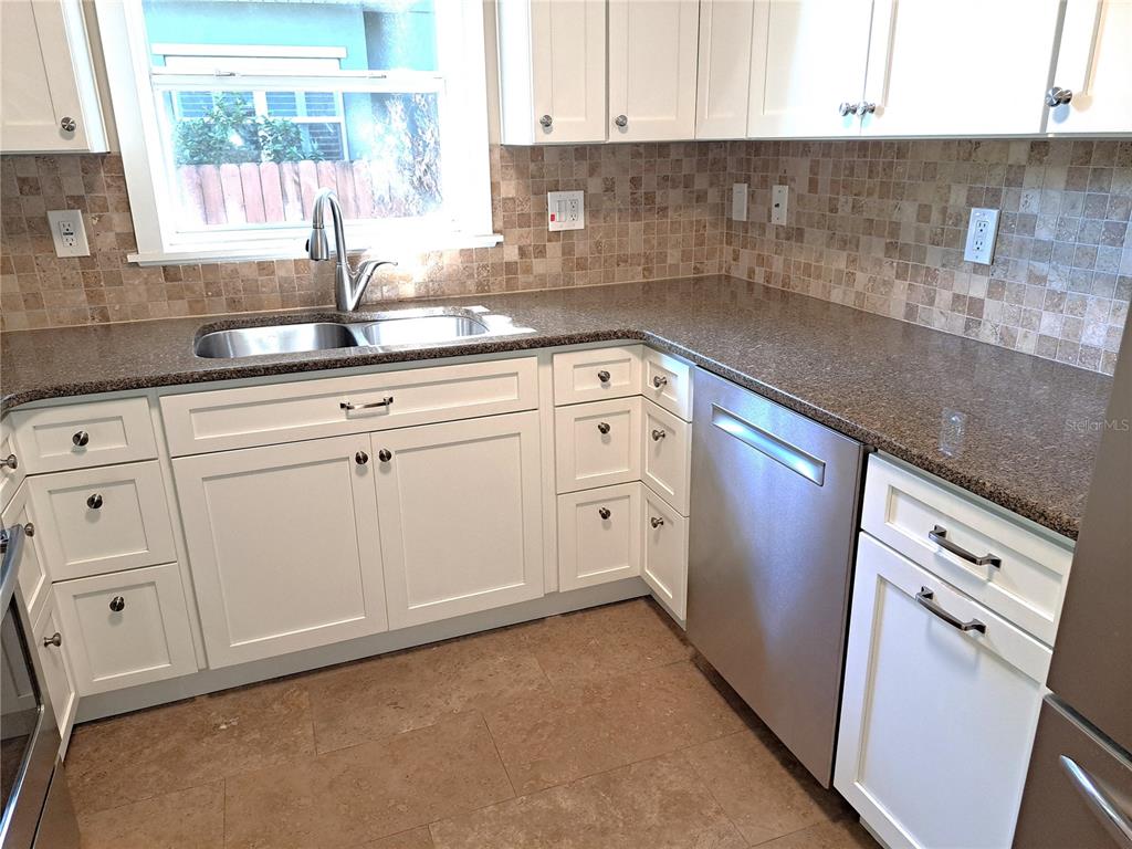 1835 Edwin Boulevard Winter Park, FL 32789 - Photo 9 of 49 a kitchen with granite countertop white cabinets and white appliances