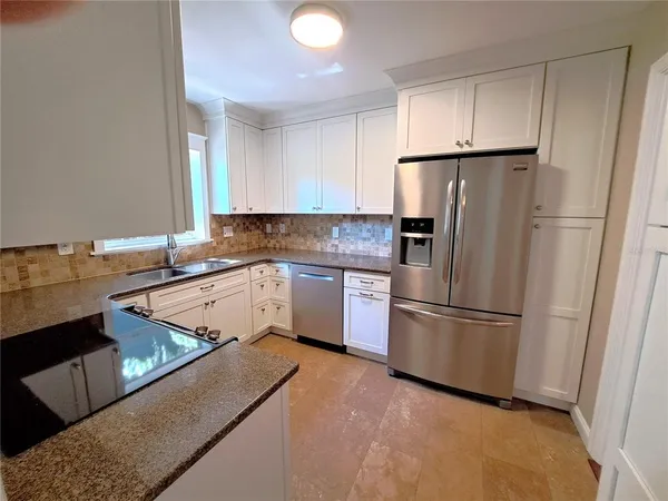 a kitchen with a refrigerator sink and cabinets