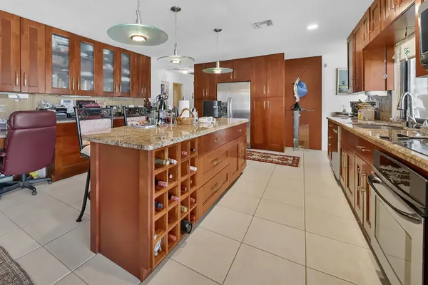 a open kitchen with stainless steel appliances granite countertop a stove top oven a sink dishwasher and a refrigerator with cabinets