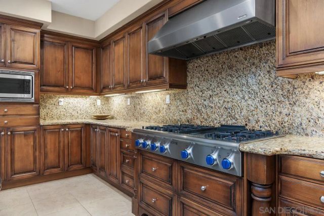 a kitchen with stainless steel appliances wooden cabinets and a stove top oven