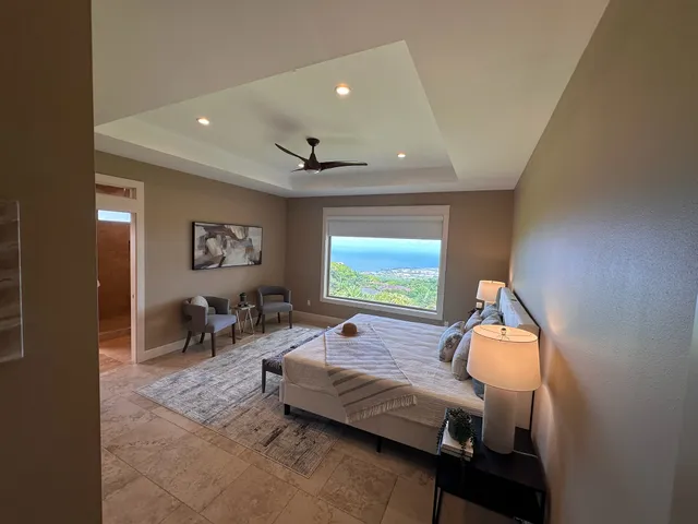 a spacious bedroom with a bed and a chandelier