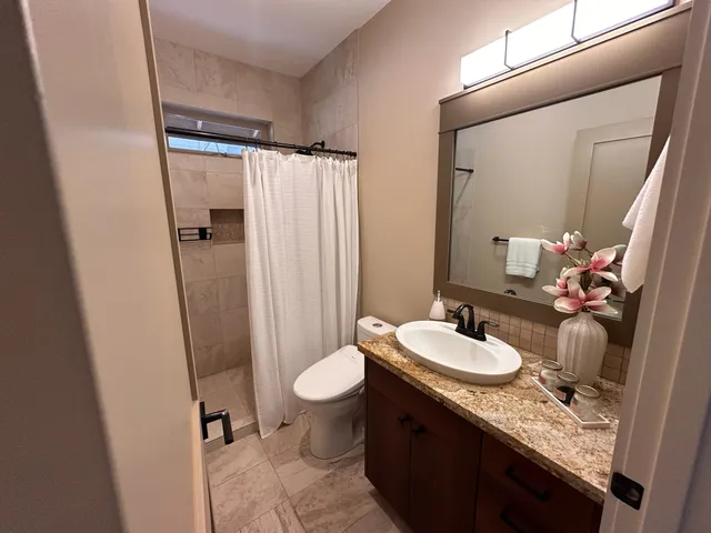 a kitchen with stainless steel appliances granite countertop a refrigerator a sink a stove and wooden cabinets