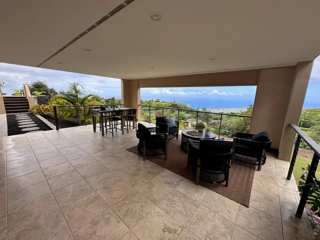 a view of a balcony with furniture and a floor to ceiling window