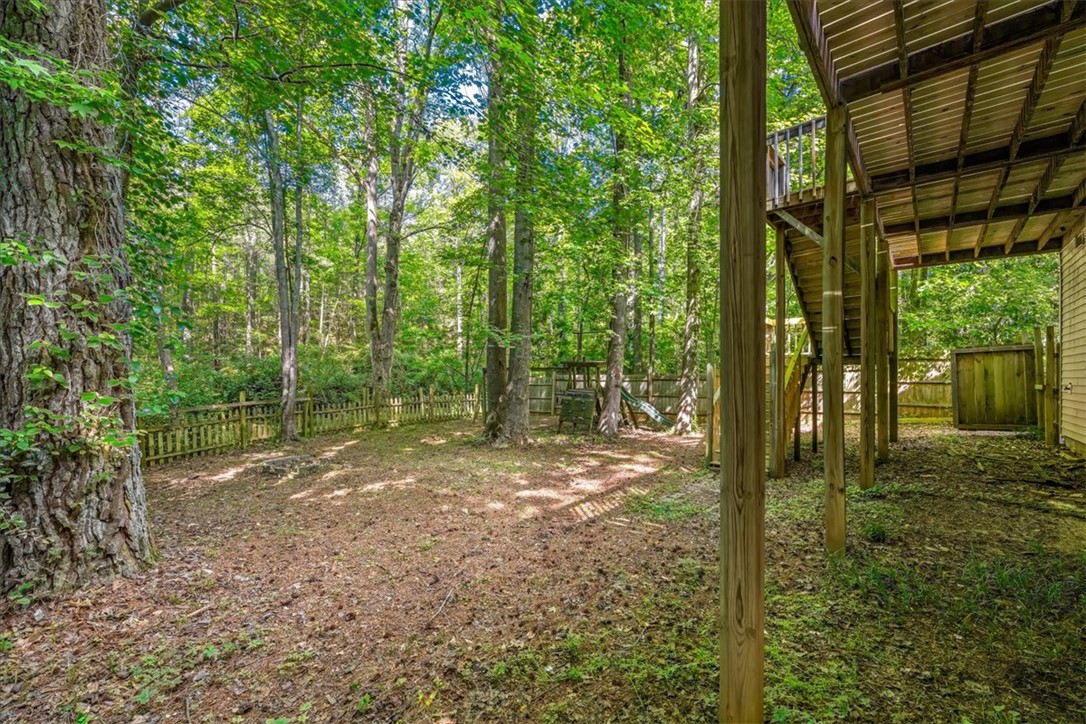 210 Briarcliff Road Central, SC 29630 - Photo 36 of 39 Enjoy the serene outdoor space with a wooden fence, surrounded by lush trees, perfect for tranquil living.