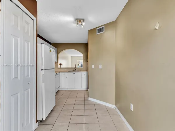 a kitchen with white cabinets and white appliances