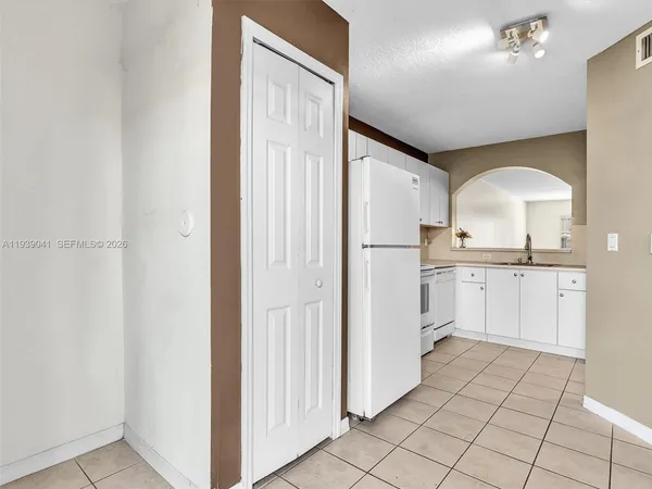 a kitchen with granite countertop white cabinets white appliances and sink
