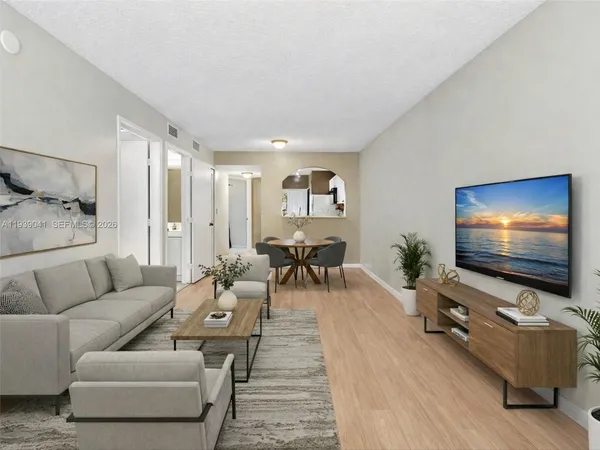 a view of a big room with wooden floor and windows