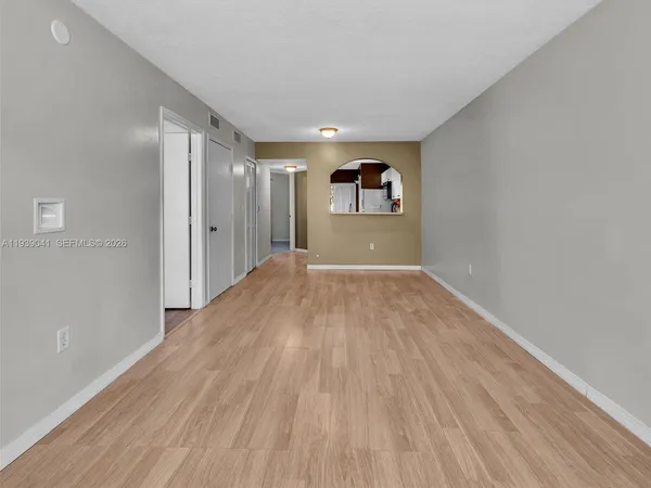 a view of empty room with wooden floor