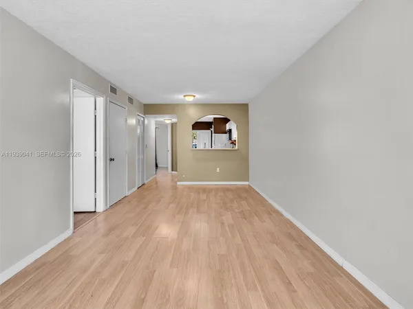 a view of an empty room with wooden floor