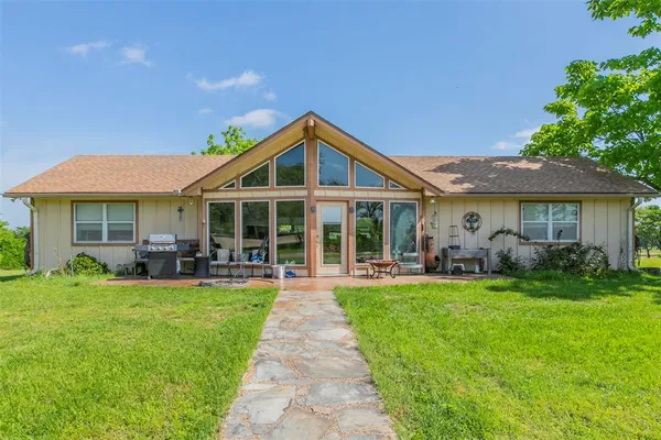 a living room with furniture large window and wooden floor