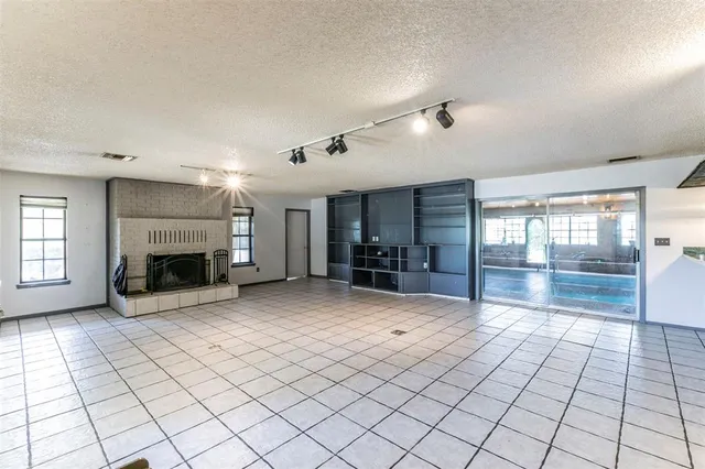 a view of empty room with fireplace and windows