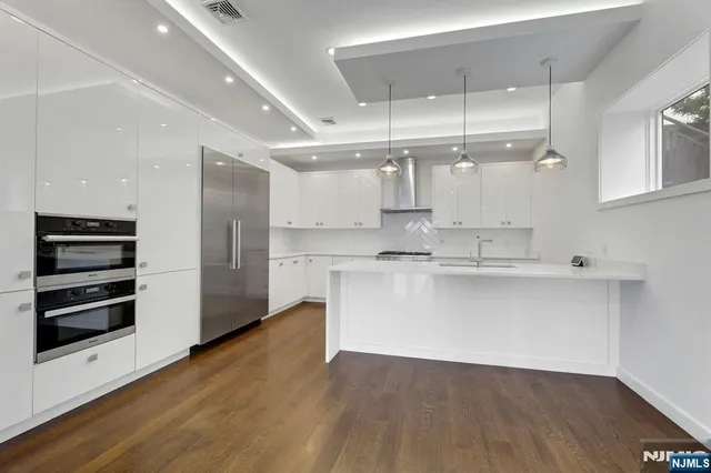 a large white kitchen with a white wooden cabinets