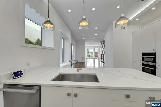 a kitchen with a sink a counter space and stainless steel appliances
