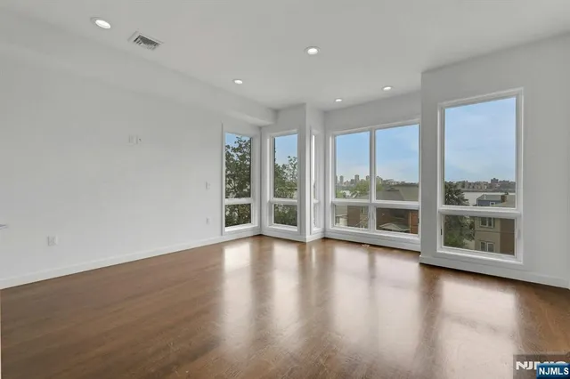 a view of empty room with wooden floor and fireplace