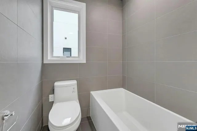 a white toilet sitting next to a white tub