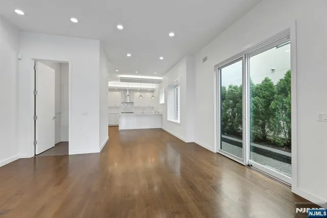 a view of empty room with wooden floor and windows