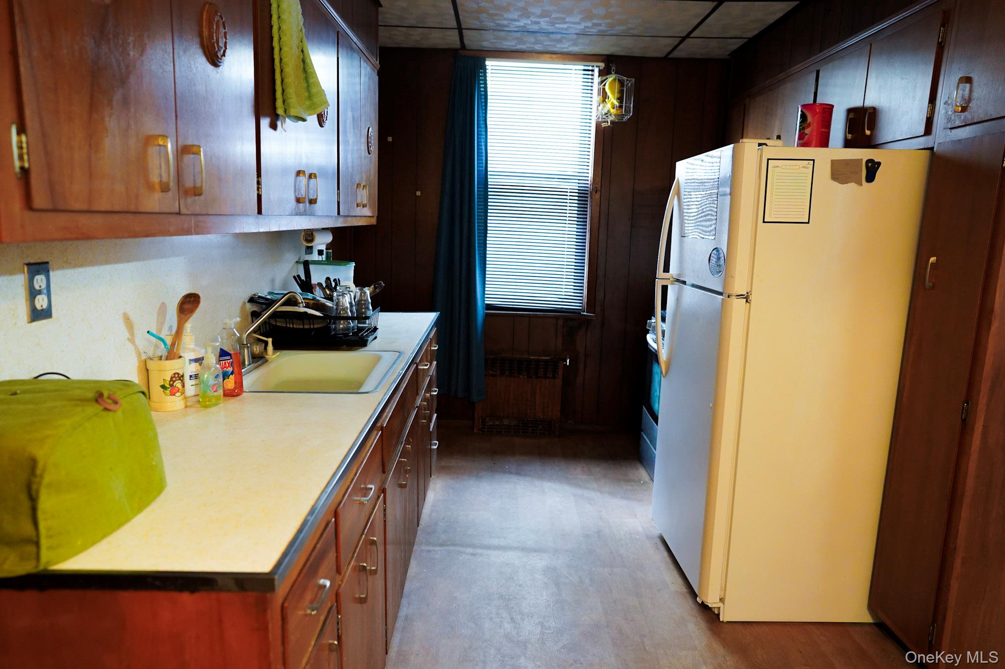 80-33 90th Road Queens, NY 11421 - Photo 13 of 20 a kitchen with sink refrigerator and cabinets