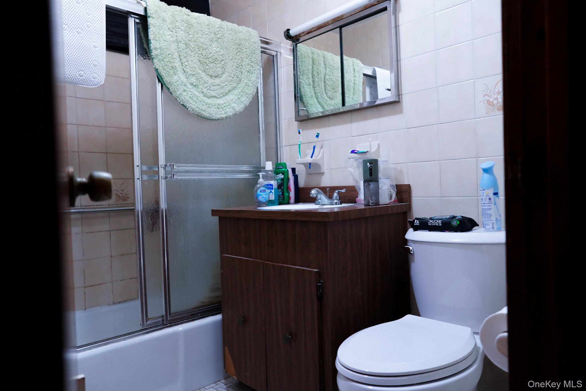 80-33 90th Road Queens, NY 11421 - Photo 16 of 20 a bathroom with a granite countertop toilet sink and mirror