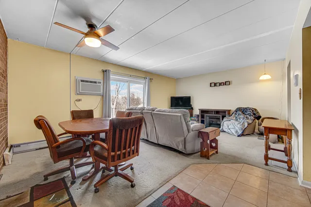 a living room with furniture a chandelier and a dining table with wooden floor