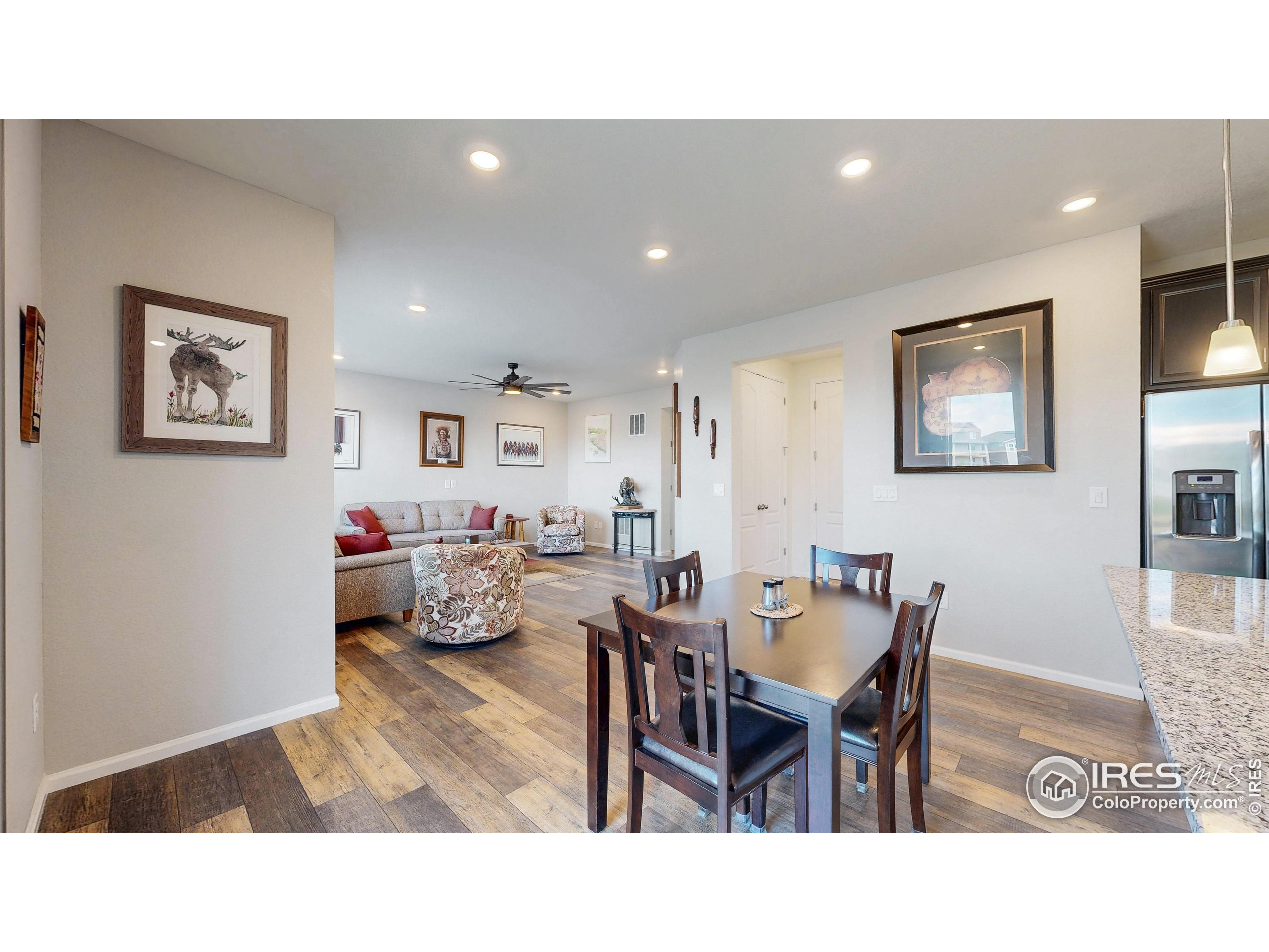 4861 St Vrain Road Firestone, CO 80504 - Photo 11 of 43 a living room with furniture and a dining table with bookshelf