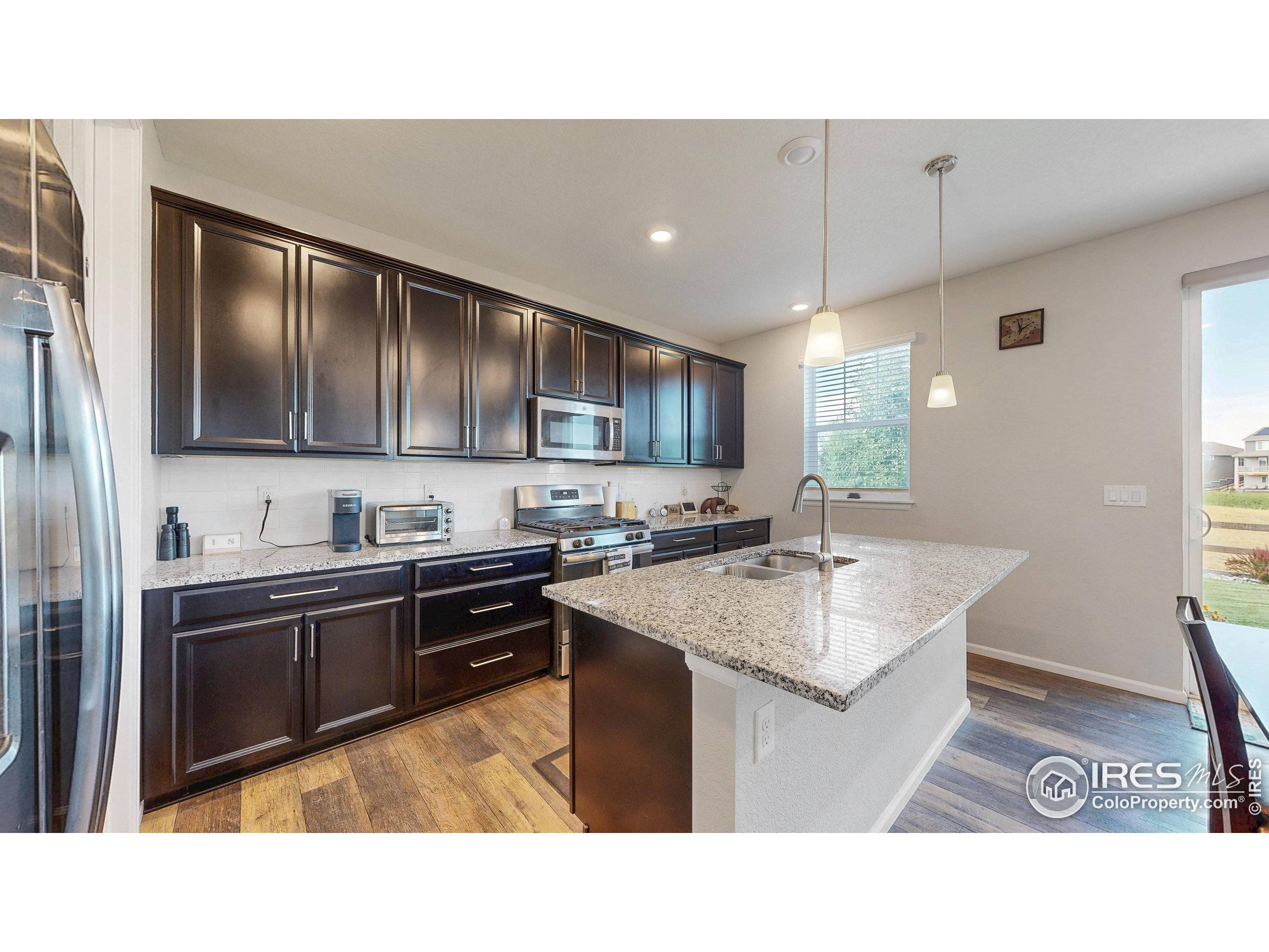 4861 St Vrain Road Firestone, CO 80504 - Photo 8 of 43 a kitchen with stainless steel appliances granite countertop a sink stove and refrigerator