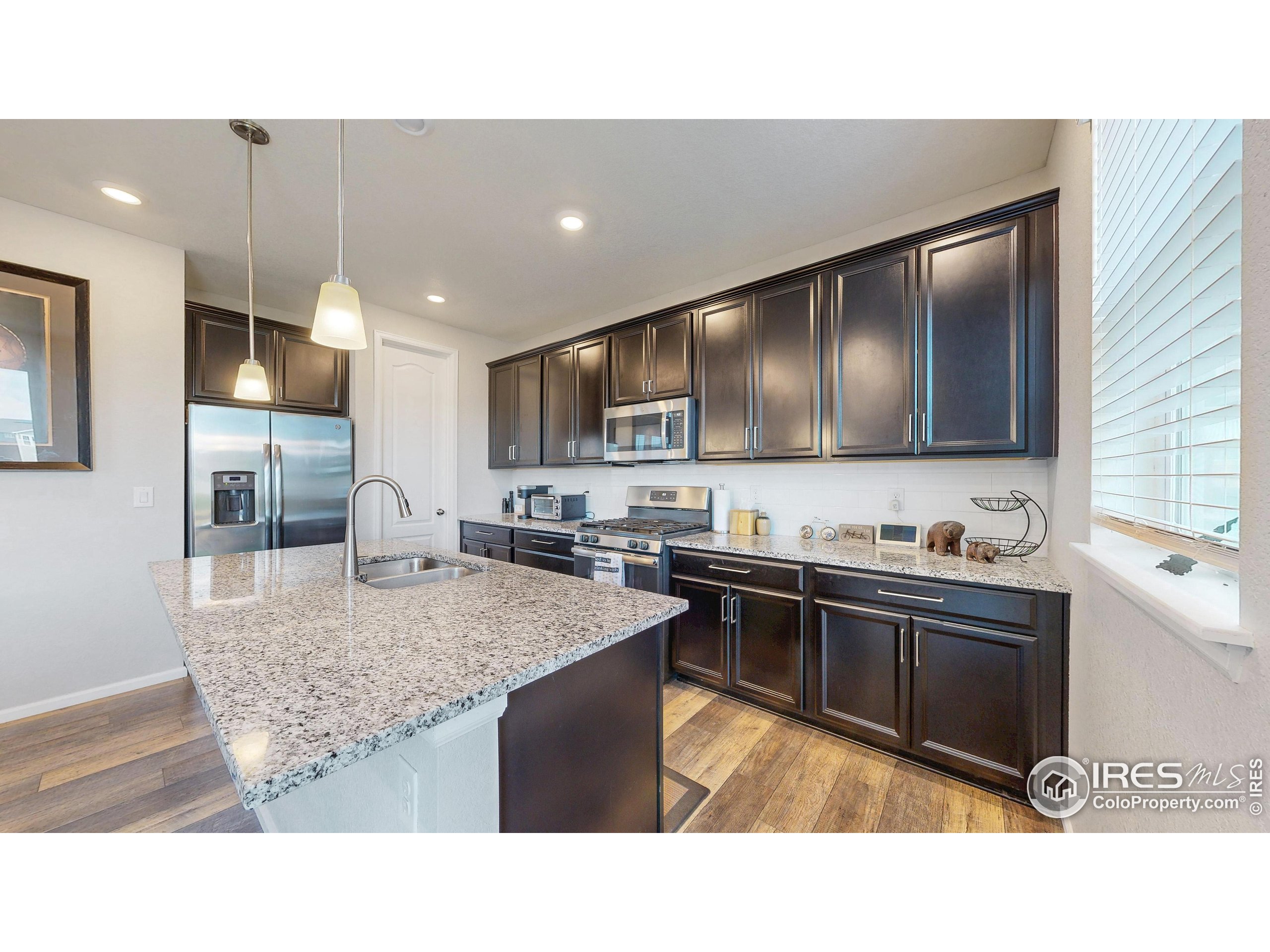 4861 St Vrain Road Firestone, CO 80504 - Photo 9 of 43 a kitchen with stainless steel appliances granite countertop a sink stove and refrigerator