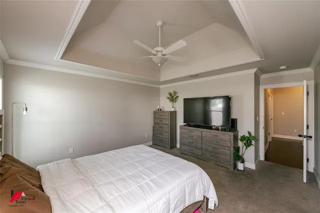 a bedroom with a bed and a flat tv screen on dresser