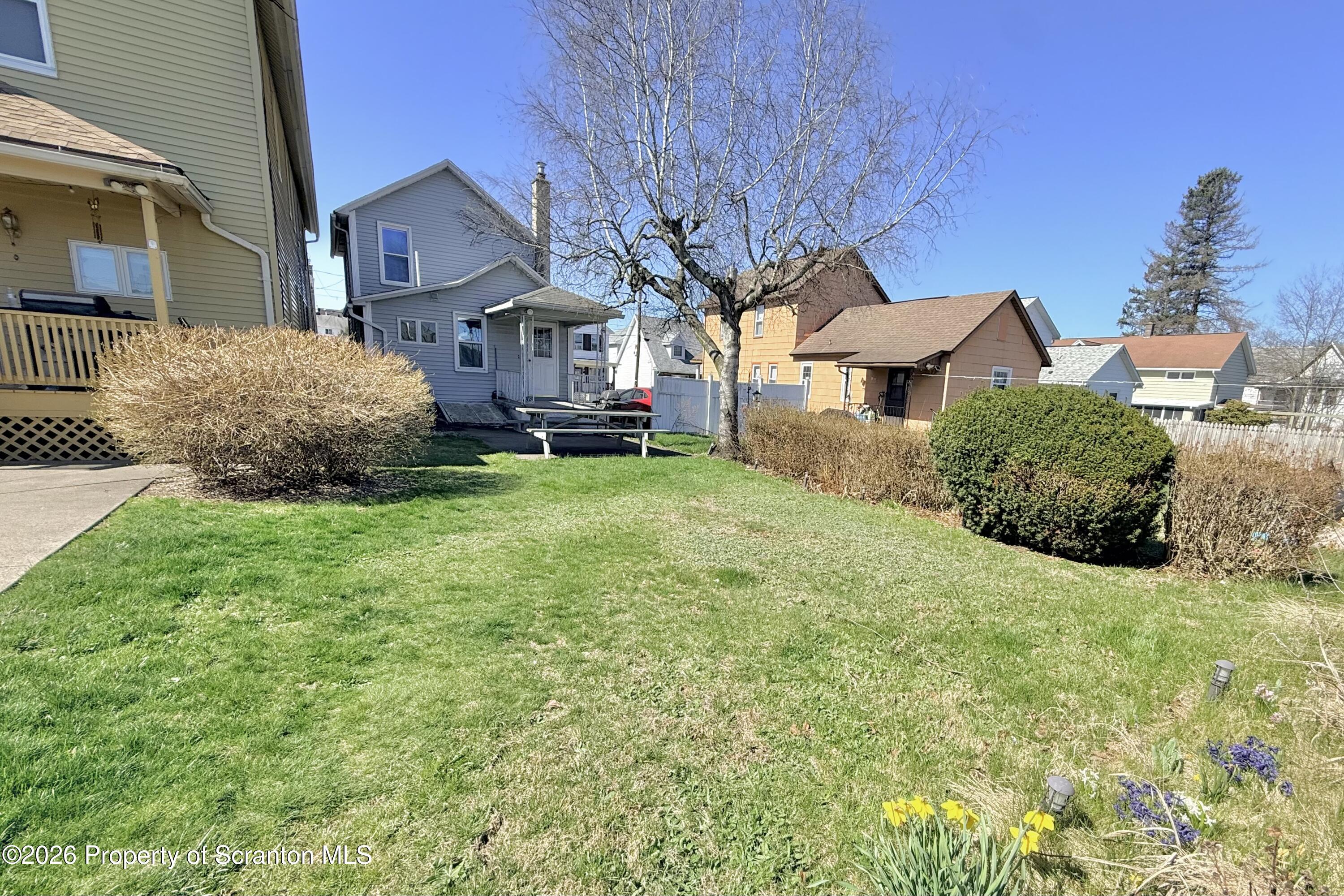 313 Dolph Street Jessup, PA 18434 - Photo 4 of 29 a front view of a house with a garden and trees