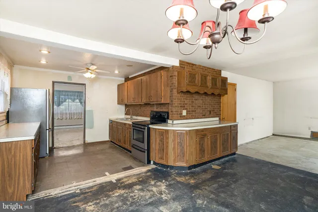a kitchen with a stove a refrigerator and a chandelier