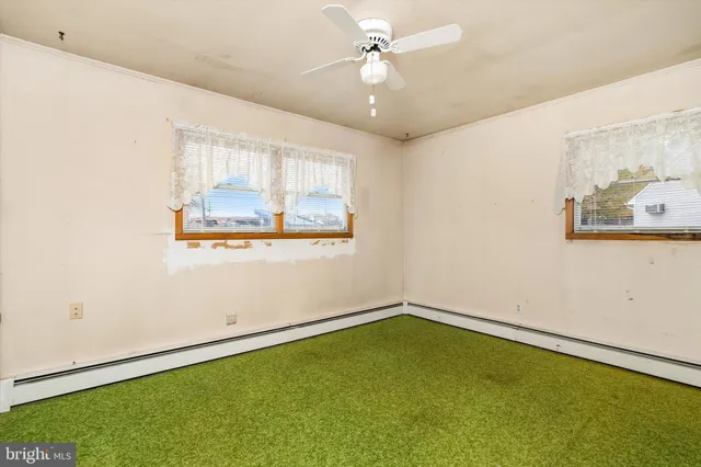 an empty room with a window and a ceiling fan