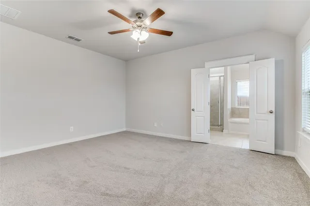 an empty room with chandelier fan
