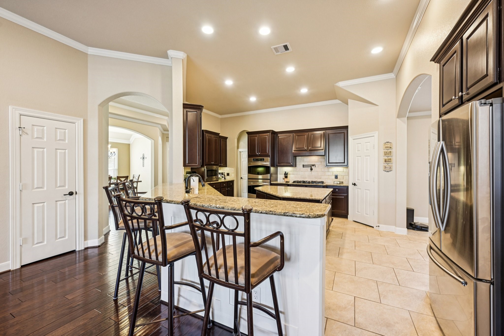 25214 East Titan Springs Drive Spring, TX 77389 - Photo 13 of 44 a kitchen with stainless steel appliances kitchen island granite countertop a refrigerator and microwave