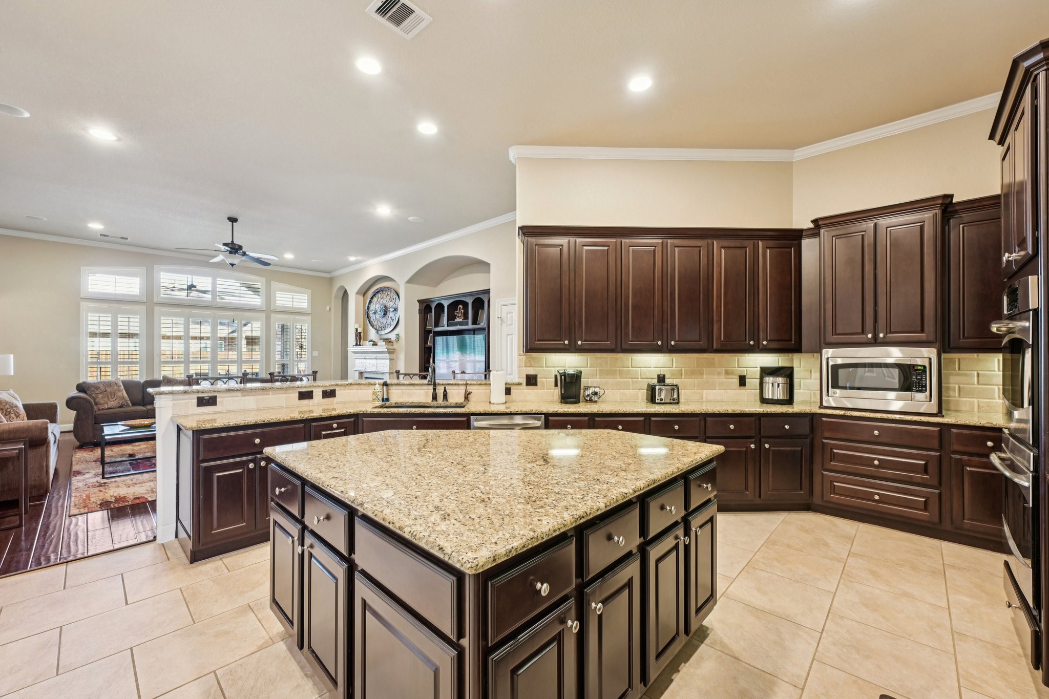25214 East Titan Springs Drive Spring, TX 77389 - Photo 14 of 44 a kitchen with granite countertop a sink counter top space appliances and cabinets
