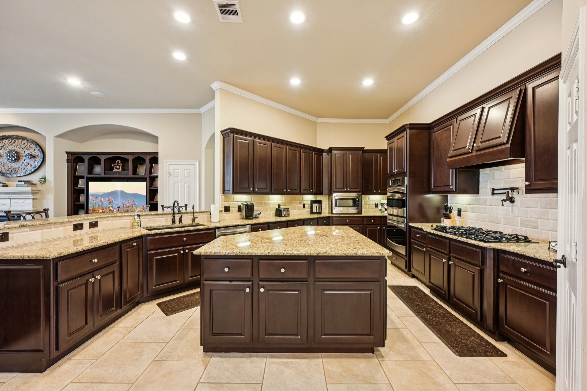 25214 East Titan Springs Drive Spring, TX 77389 - Photo 15 of 44 a large kitchen with stainless steel appliances granite countertop a sink and cabinets